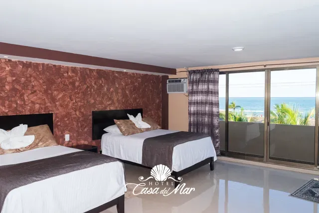 Dos camas matrimoniales y un ventanal de piso a techo hacia el mar · Hotel Casa del Mar
