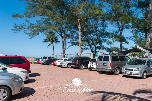 Estacionamiento amplio a la sombra de los pinos, junto a la playa · Hotel Casa del Mar