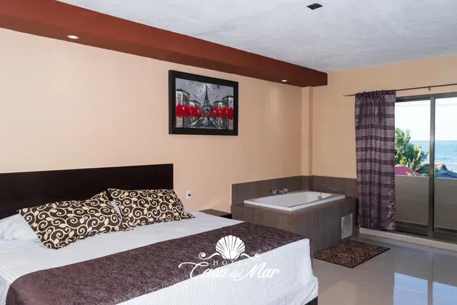 Cama king size, jacuzzi y balcón con vista al mar · Hotel Casa del Mar